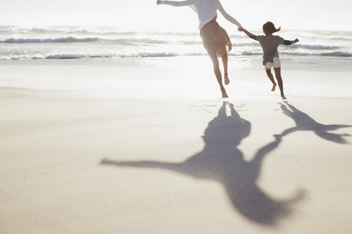 Mother and Child Running On The Beach